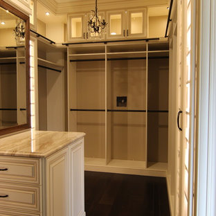 Foto de armario vestidor tradicional, grande, con armarios con paneles con relieve, puertas de armario beige, suelo de madera oscura y suelo marrón