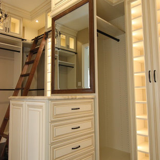 Ejemplo de armario vestidor clásico, grande, con armarios con paneles con relieve, puertas de armario beige, suelo de madera oscura y suelo marrón
