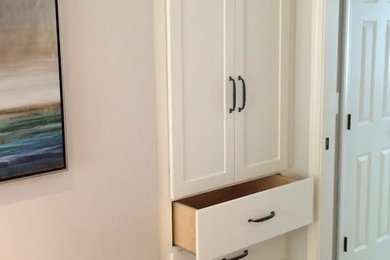 This is an example of a medium sized classic standard wardrobe in Boston with recessed-panel cabinets, white cabinets and medium hardwood flooring.