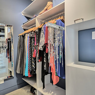 Esempio di una piccola cabina armadio unisex classica con ante lisce, ante bianche e pavimento in cemento