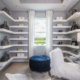 Inspiration för ett stort funkis walk-in-closet, med vita skåp och mellanmörkt trägolv