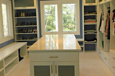 Inspiration for a large classic walk-in wardrobe for women in Other with glass-front cabinets, white cabinets and carpet.