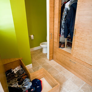 Idee per armadi e cabine armadio minimal con ante lisce, ante in legno chiaro e pavimento con piastrelle in ceramica
