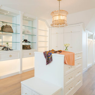 Immagine di uno spazio per vestirsi per donna mediterraneo con ante in stile shaker, ante bianche, parquet chiaro e pavimento beige