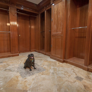 Imagen de armario vestidor unisex, clásico, grande, con puertas de armario de madera oscura y suelo de travertino