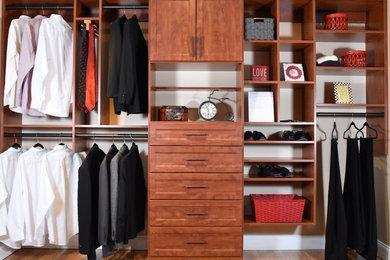 Mid-sized minimalist men's closet photo in Other with raised-panel cabinets and medium tone wood cabinets