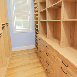 Esempio di una cabina armadio per donna stile americano di medie dimensioni con ante lisce, ante in legno chiaro e parquet chiaro