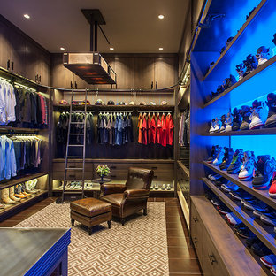 Inspiration för ett mycket stort rustikt walk-in-closet för män, med släta luckor, skåp i slitet trä, brunt golv och mörkt trägolv