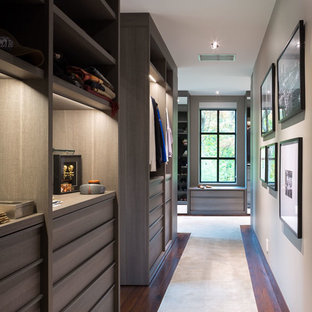 Foto di un'ampia cabina armadio per uomo minimal con ante lisce, ante in legno scuro, moquette e pavimento beige