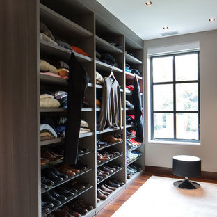 Imagen de armario vestidor de hombre, actual, extra grande, con armarios con paneles lisos, puertas de armario de madera oscura, moqueta y suelo beige
