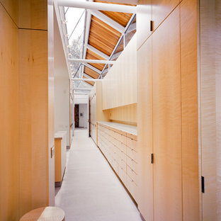 Foto de armario y vestidor moderno con armarios con paneles lisos, puertas de armario de madera clara y suelo de piedra caliza