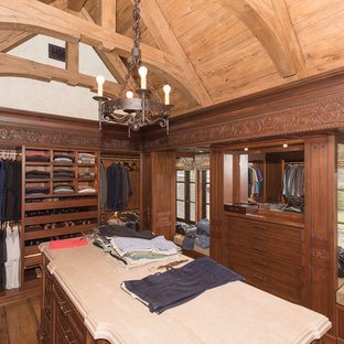 Immagine di una grande cabina armadio per donna mediterranea con ante con riquadro incassato, ante beige, parquet scuro e pavimento bianco