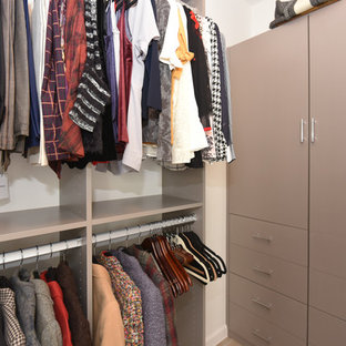 Imagen de armario vestidor unisex, vintage, con armarios con paneles lisos, puertas de armario beige, suelo de baldosas de porcelana y suelo beige