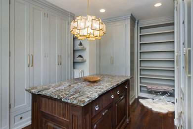 Example of a mid-sized classic gender-neutral dark wood floor and brown floor dressing room design in Tampa with beaded inset cabinets and gray cabinets
