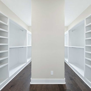 Ispirazione per una cabina armadio unisex industriale di medie dimensioni con ante in stile shaker, ante bianche, pavimento in legno massello medio e pavimento marrone