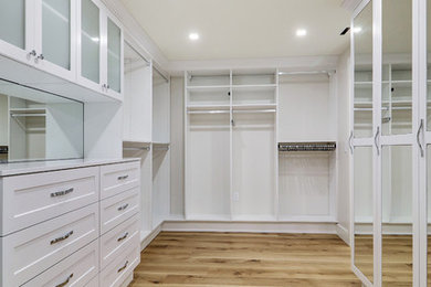 Large trendy gender-neutral light wood floor and beige floor walk-in closet photo in Miami with shaker cabinets and white cabinets
