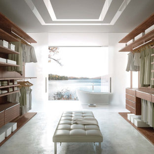 Foto de armario vestidor unisex, moderno, grande, con armarios con paneles lisos, puertas de armario de madera oscura y moqueta