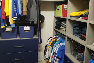 Walk-in closet - small modern men's walk-in closet idea in Atlanta with flat-panel cabinets and blue cabinets