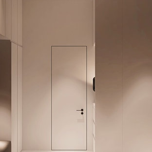 Imagen de vestidor unisex, moderno, de tamaño medio, con armarios abiertos, puertas de armario blancas, suelo de cemento y suelo gris