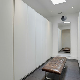 Imagen de armario vestidor unisex, minimalista, con armarios con paneles lisos, puertas de armario blancas, suelo de baldosas de cerámica y suelo marrón