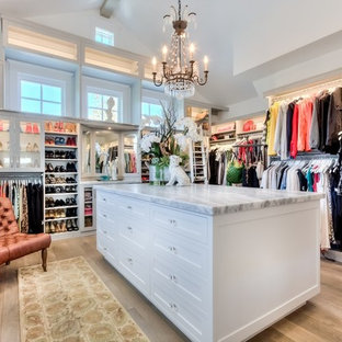 Inspiration for a huge country women's light wood floor walk-in closet remodel in Orange County with open cabinets and white cabinets