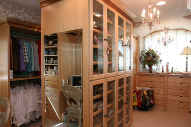 Diseño de vestidor unisex clásico grande con armarios tipo vitrina, puertas de armario de madera clara, moqueta y suelo beige