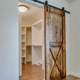 Idee per una cabina armadio unisex country di medie dimensioni con pavimento in legno massello medio e pavimento marrone