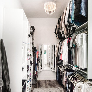 Large women's medium tone wood floor walk-in closet photo in Other with open cabinets
