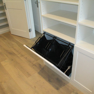 Bild på ett stort maritimt walk-in-closet för könsneutrala, med skåp i shakerstil, vita skåp och ljust trägolv