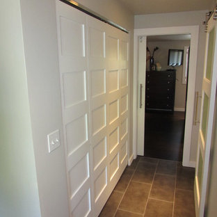 Imagen de armario unisex, moderno, pequeño, con puertas de armario blancas y suelo de baldosas de porcelana