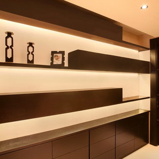 Ispirazione per una cabina armadio moderna di medie dimensioni con ante lisce e ante in legno bruno