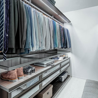 Esempio di una grande cabina armadio per uomo moderna con ante di vetro, ante in legno bruno, pavimento in laminato e pavimento bianco