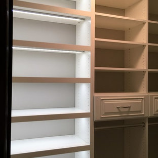 Exempel på ett mellanstort klassiskt walk-in-closet, med luckor med upphöjd panel, vita skåp och heltäckningsmatta