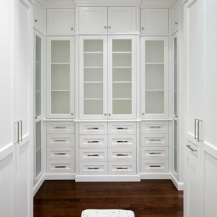 Immagine di un'ampia cabina armadio per donna chic con ante con riquadro incassato, ante bianche e parquet scuro