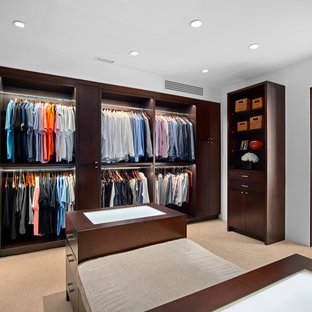 Modelo de vestidor de hombre, exótico, con armarios abiertos, puertas de armario de madera en tonos medios, moqueta y suelo beige