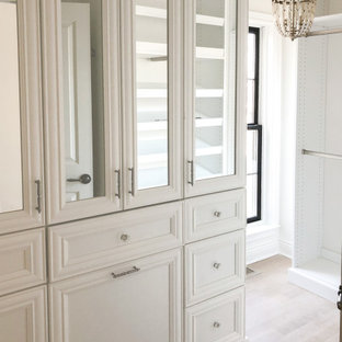 Immagine di un piccolo spazio per vestirsi per donna stile shabby con ante con riquadro incassato, ante bianche, parquet chiaro e pavimento beige