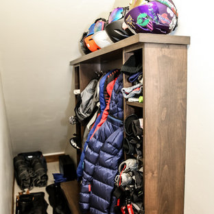 Ejemplo de armario vestidor unisex, minimalista, de tamaño medio, con armarios estilo shaker, puertas de armario de madera oscura, suelo de travertino y suelo blanco