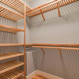 Esempio di una cabina armadio unisex stile americano di medie dimensioni con ante con bugna sagomata, ante in legno chiaro e parquet scuro