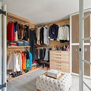 Ejemplo de vestidor unisex, clásico renovado, con armarios con paneles lisos, puertas de armario de madera clara y moqueta