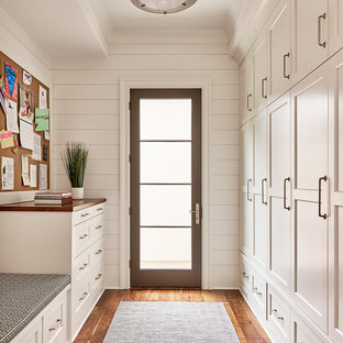 Foto de armario vestidor unisex, tradicional renovado, con armarios estilo shaker, puertas de armario blancas y suelo de madera en tonos medios