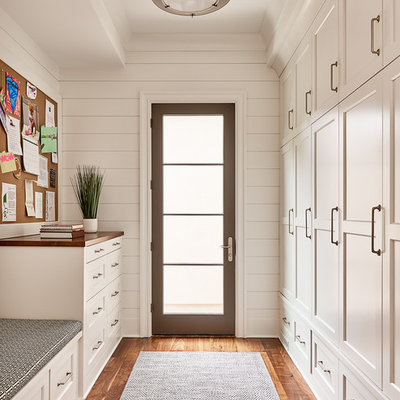 Transitional gender-neutral medium tone wood floor walk-in closet photo in Charlotte with shaker cabinets and white cabinets