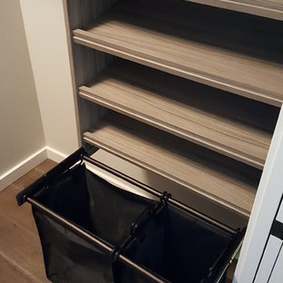 Foto di una cabina armadio unisex minimal di medie dimensioni con nessun'anta, ante in legno scuro e parquet scuro