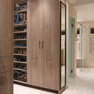 Idées déco pour un dressing contemporain neutre avec un placard à porte plane, des portes de placard en bois clair, un sol en carrelage de porcelaine et un sol beige.