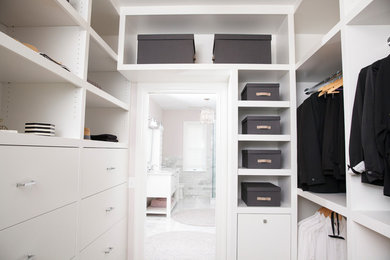 Imagen de armario vestidor unisex clásico renovado de tamaño medio con armarios con paneles lisos, puertas de armario blancas, suelo de madera oscura y suelo marrón