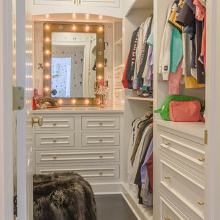 Immagine di una cabina armadio per donna classica di medie dimensioni con ante con riquadro incassato, ante gialle, parquet scuro e pavimento marrone
