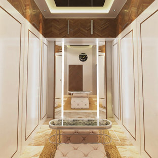 Ispirazione per una cabina armadio unisex minimal di medie dimensioni con ante lisce, ante bianche, pavimento in marmo, pavimento beige e soffitto in perlinato