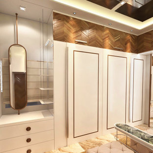 Idee per una cabina armadio unisex design di medie dimensioni con ante lisce, ante bianche, pavimento in marmo, pavimento beige e soffitto in perlinato