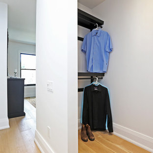 Modelo de armario vestidor unisex, nórdico, de tamaño medio, con armarios abiertos, puertas de armario de madera en tonos medios y suelo de madera clara