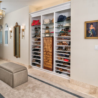 Immagine di una grande cabina armadio per donna mediterranea con pavimento in gres porcellanato e pavimento beige