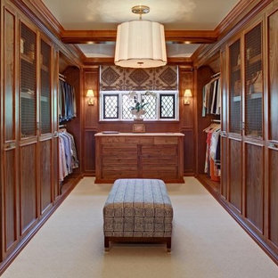 Esempio di una grande cabina armadio unisex classica con ante con riquadro incassato, moquette e ante in legno scuro